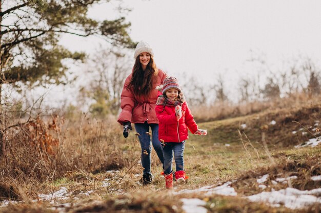 Mãe com filha em uma floresta de inverno