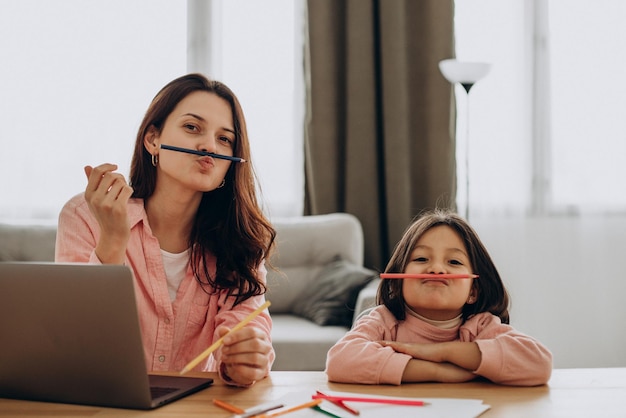 Mãe com filha estudando em casa