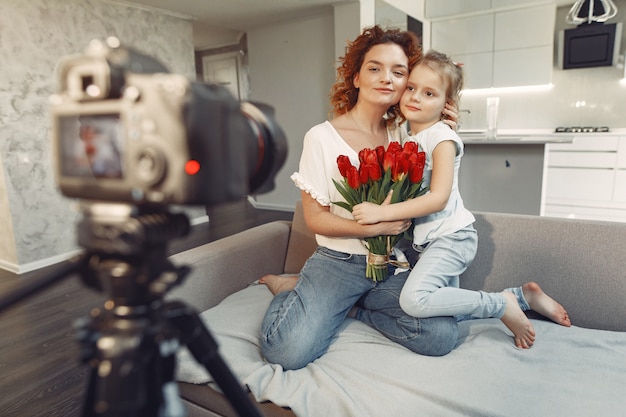 Mãe com filha filma um blog em casa