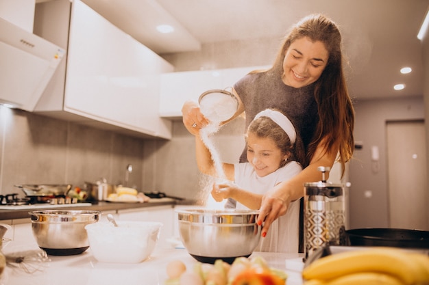 Mãe com filha juntos a cozinhar na cozinha