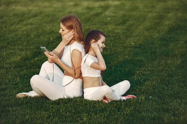 Mãe com filha ouvindo música em um parque