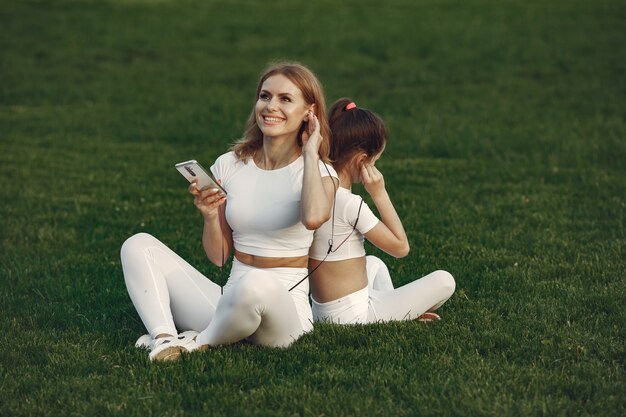 Mãe com filha ouvindo música em um parque