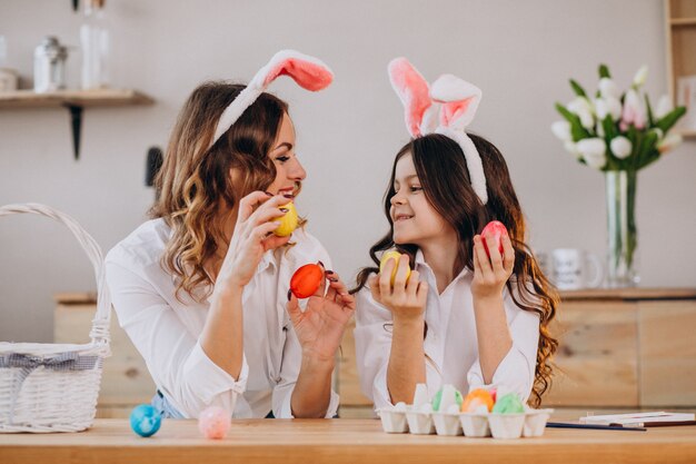 Mãe com filha pintando ovos para a Páscoa