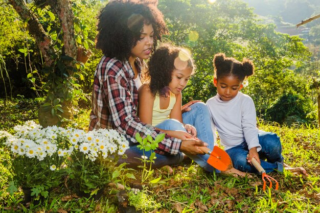 Mãe com filhas na grama