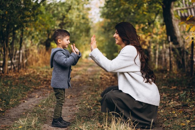 Mãe com filho pequeno em um parque de outono