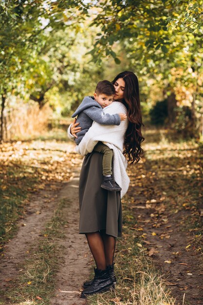 Mãe com filho pequeno em um parque de outono