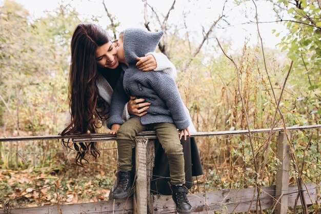 Mãe com filho pequeno em um parque de outono