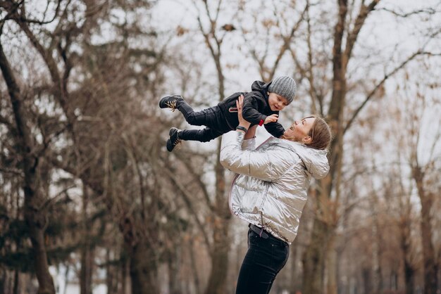 Mãe com filho pequeno juntos no parque outono