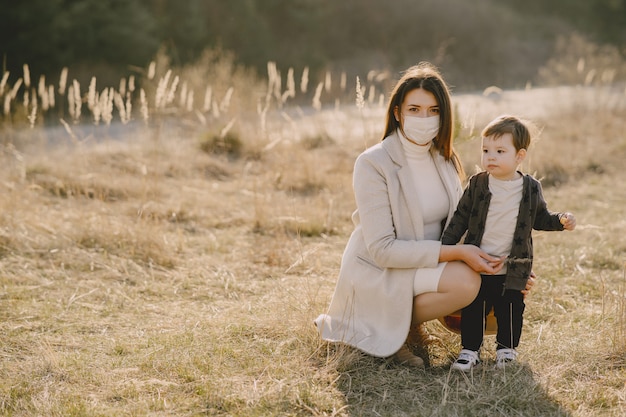 Mãe com filho pequeno usando máscaras