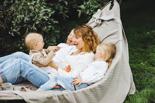 mãe com filhos se divertindo em uma rede. Mãe e filhos em uma rede.