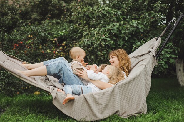 mãe com filhos se divertindo em uma rede. Mãe e filhos em uma rede.