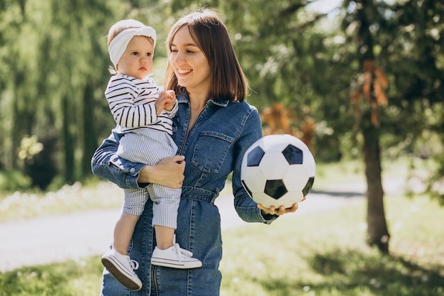 Mãe com menina brincando com bola no parque