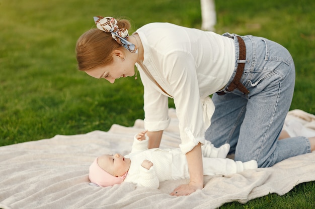 Foto grátis mãe com seu bebê passar o tempo em um jardim de verão