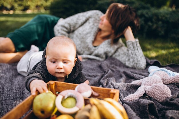 Mãe com seu filho pequeno fazendo piquenique em um quintal