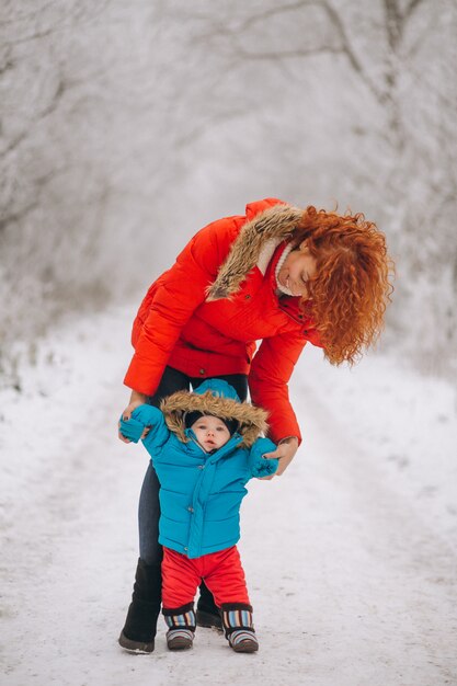 Mãe com seu filho pequeno juntos em um parque de inverno