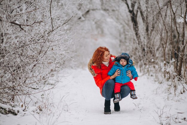 Mãe com seu filho pequeno juntos em um parque de inverno