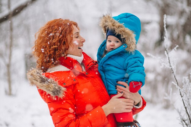 Mãe com seu filho pequeno juntos em um parque de inverno