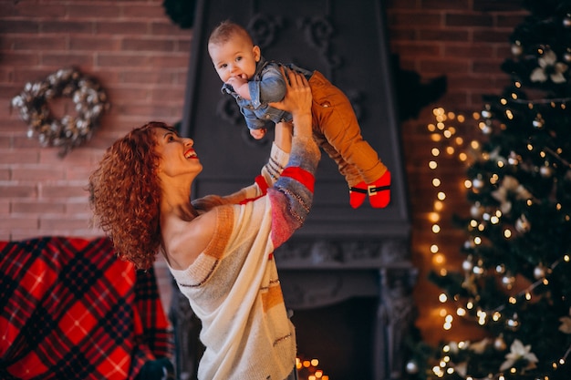 Mãe com seu filho pequeno pela árvore de Natal