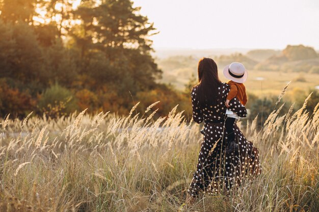 Mãe com sua filha em um campo de outono