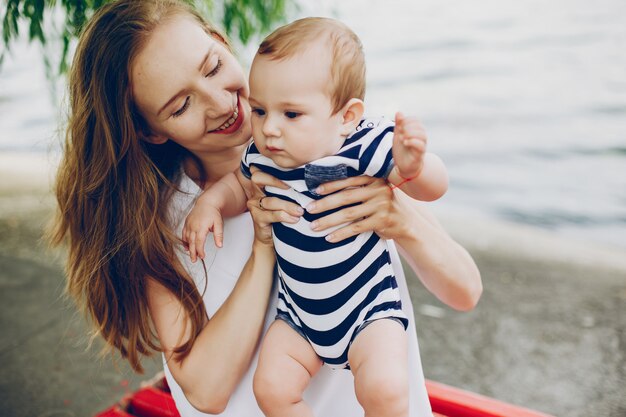 Mãe com um bebê. Caminhando no parque. Relação familiar.