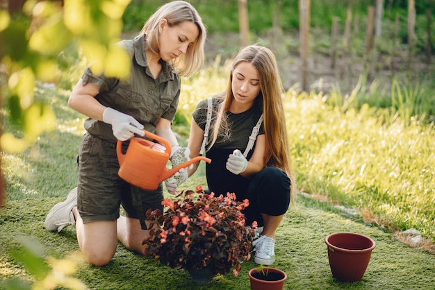 Foto grátis mãe com uma filha trabalha em um jardim perto da casa