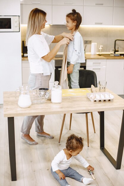 Mãe dando um avental para a filha