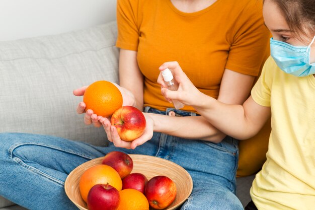 Mãe de close-up desinfecção de frutas para menina