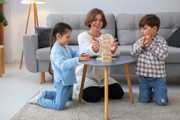 Foto grátis mãe de tiro completo brincando com crianças