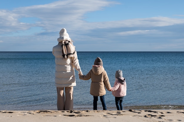 Mãe de tiro completo e filhos na praia