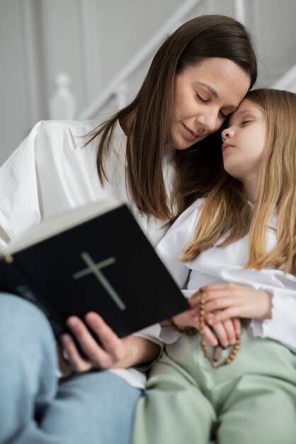 Mãe de tiro médio e menina com bíblia