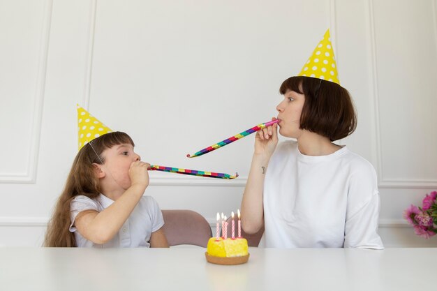 Mãe de tiro médio e menina com chifres de festa