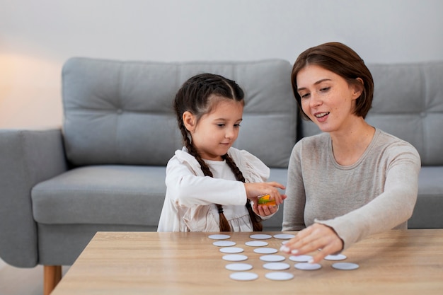 Mãe de tiro médio e menina jogando jogo