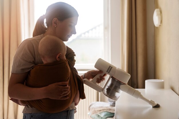 Mãe de tiro médio limpando com bebê