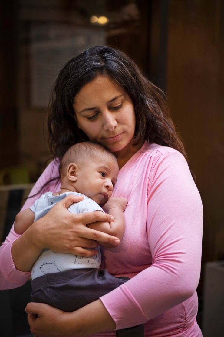 Foto grátis mãe de tiro médio segurando o bebê
