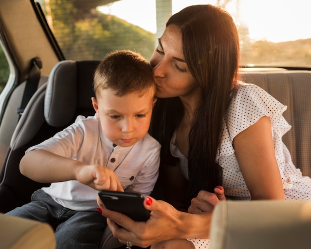 Mãe de tiro médio segurando o telefone