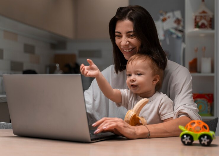 Foto grátis mãe de tiro médio trabalhando e segurando o bebê
