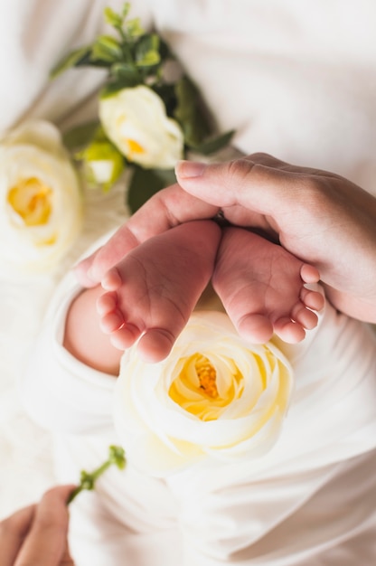 Mãe do concurso de cultivo segurando os pés do bebê