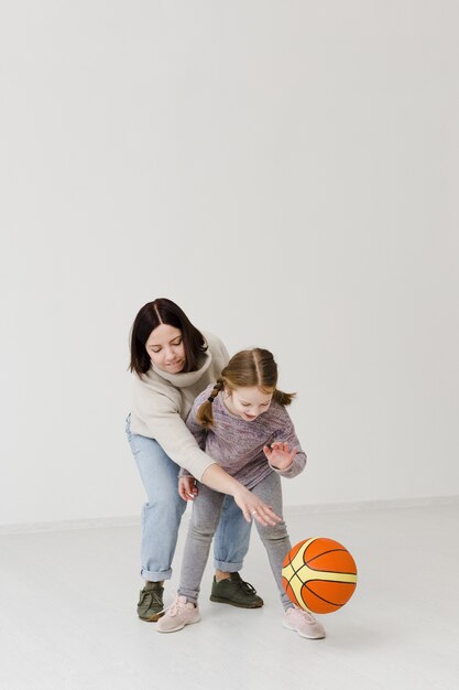 Mãe e criança jogando basquete