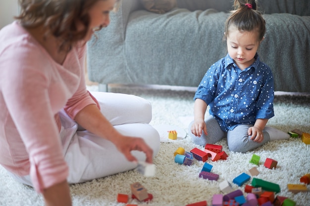 Mãe e filha a brincar com brinquedos