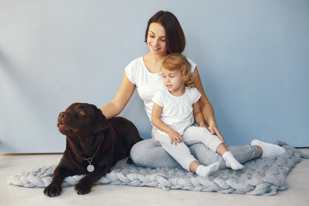 Mãe e filha brincando com cachorro em casa