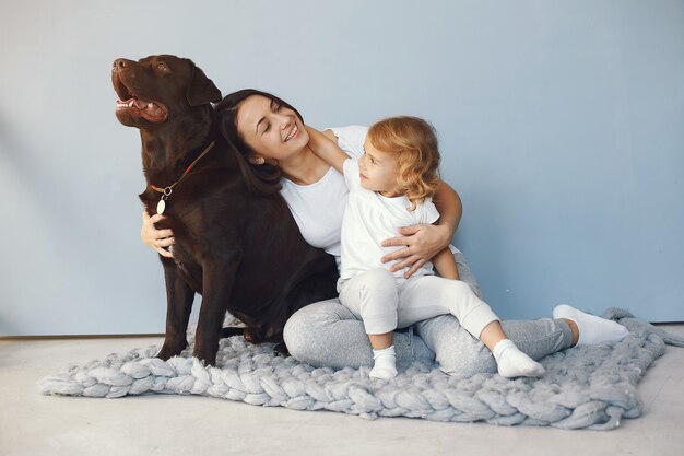 Mãe e filha brincando com cachorro em casa