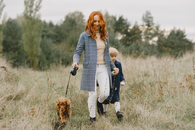 Mãe e filha brincando com o cachorro. Família no parque outono. Animal de estimação, animal doméstico e conceito de estilo de vida. Tempo de outono.