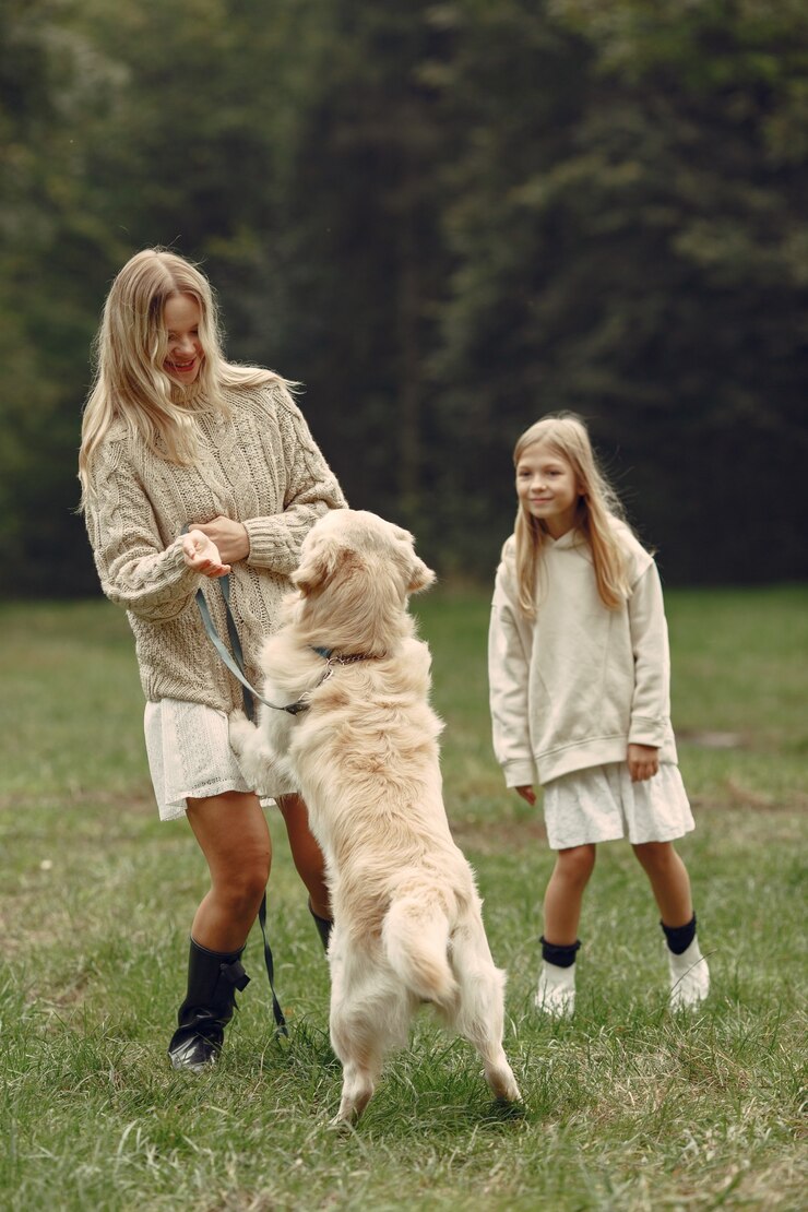Foto grátis mãe e filha brincando com o cachorro. família no parque outono. animal de estimação, animal doméstico e conceito de estilo de vida