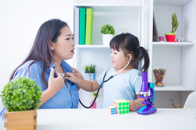 Mãe e filha brincando de médico com estetoscópio