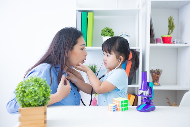 Mãe e filha brincando de médico com estetoscópio