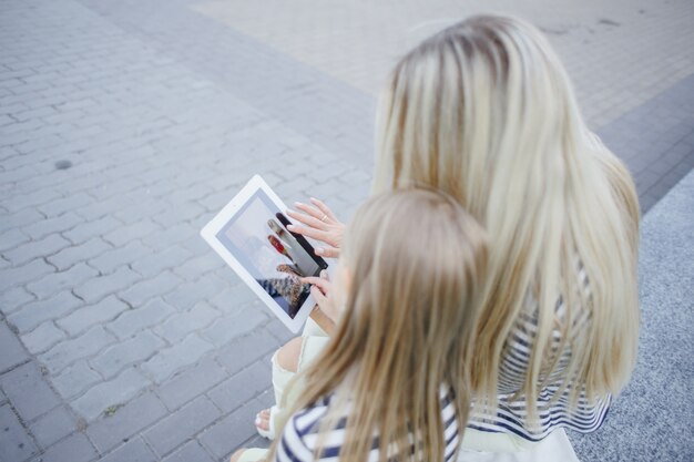 Mãe e filha com um tablet nas mãos