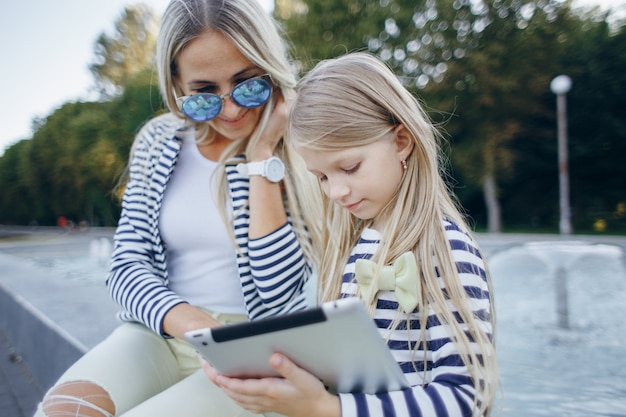 Mãe e filha com um tablet nas mãos