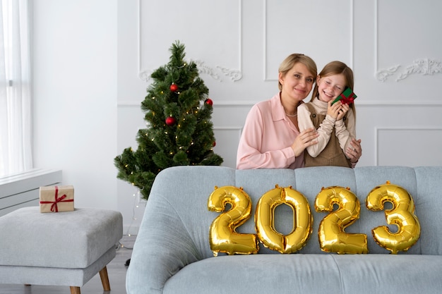 Foto grátis mãe e filha comemorando a véspera de ano novo em casa juntos