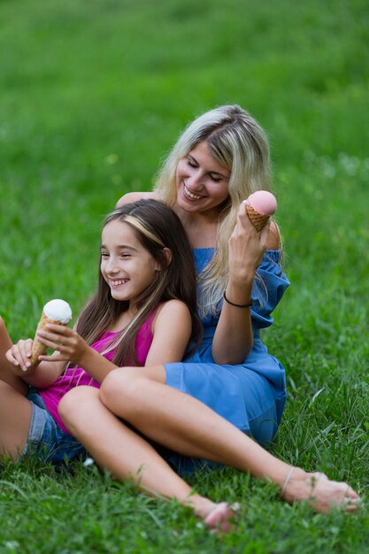 Mãe e filha comendo sorvete no parque