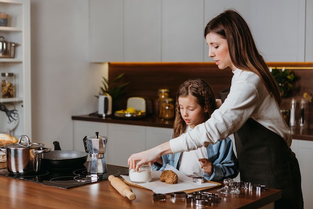 Mãe e filha cozinhando na cozinha